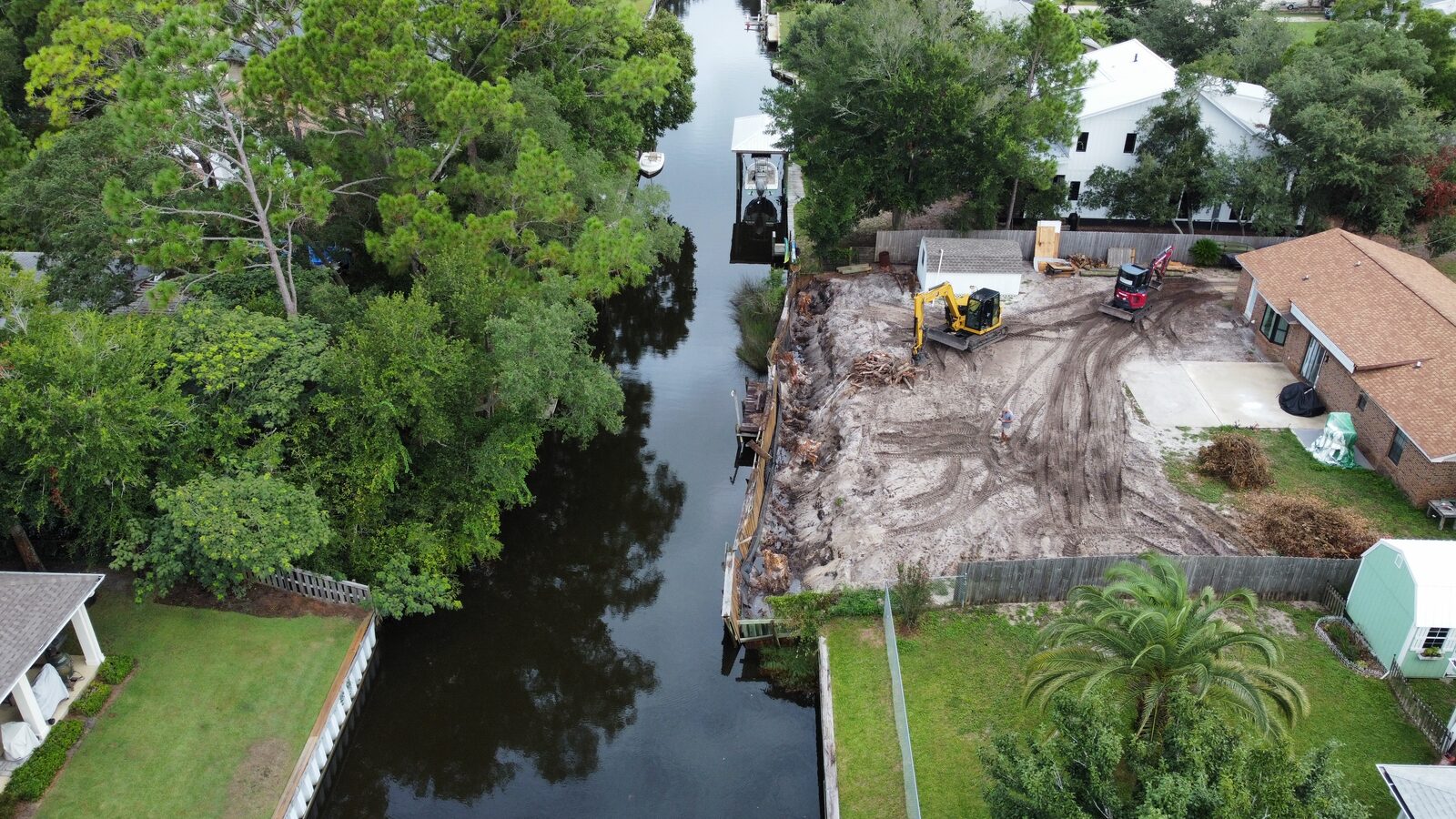 Barge-mounted equipment repairing a failing seawall on the Alabama Gulf Coast