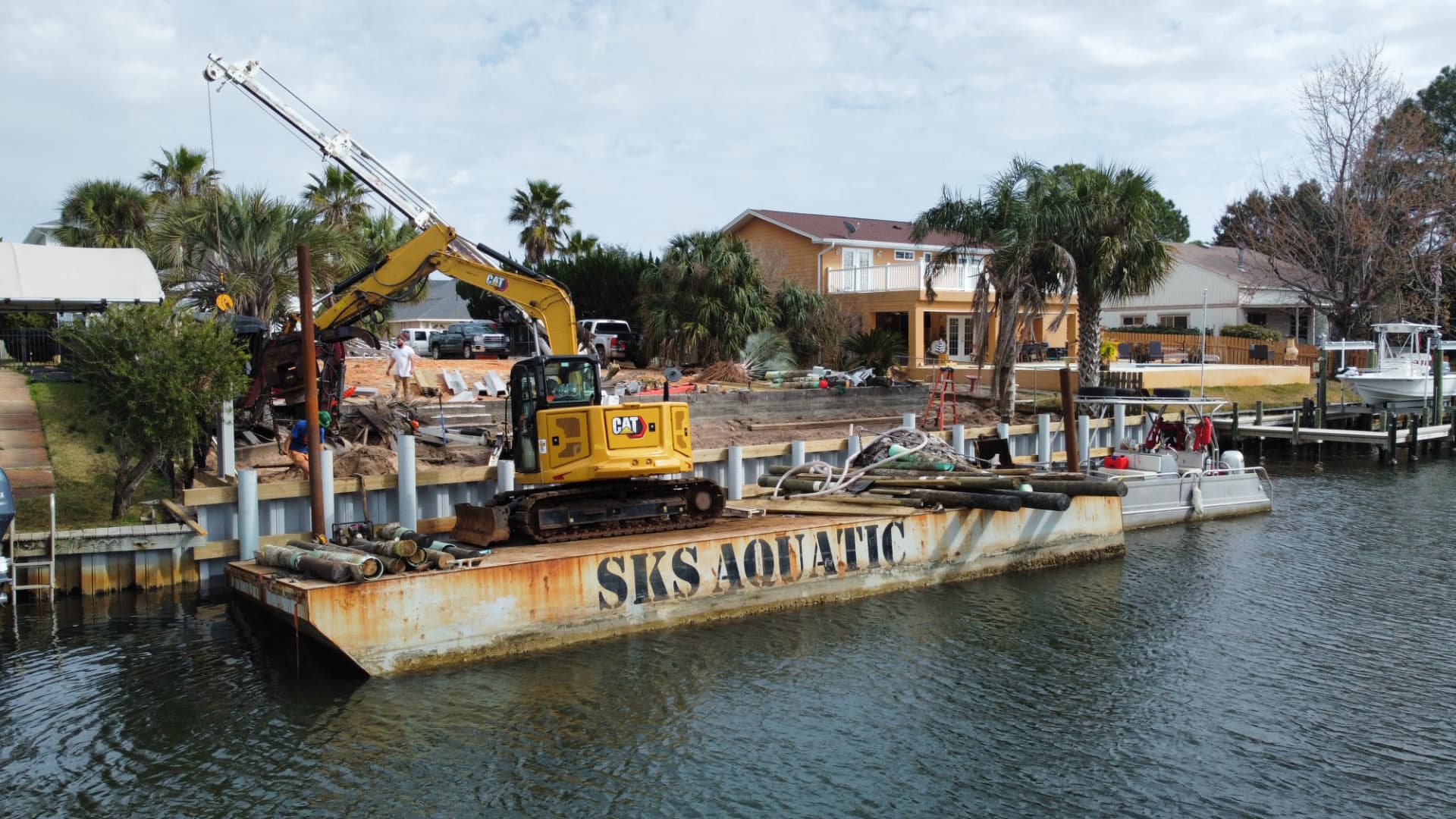 SKS Aquatic work barge and excavator at an active seawall construction site
