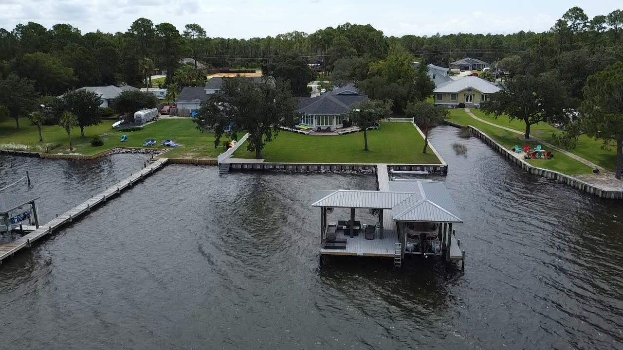 Aerial of a covered boathouse and seawall shoreline by SKS Aquatic