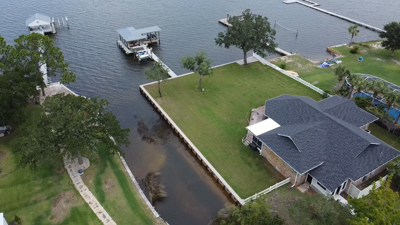 Aerial of a waterfront property with SKS Aquatic seawall and dock