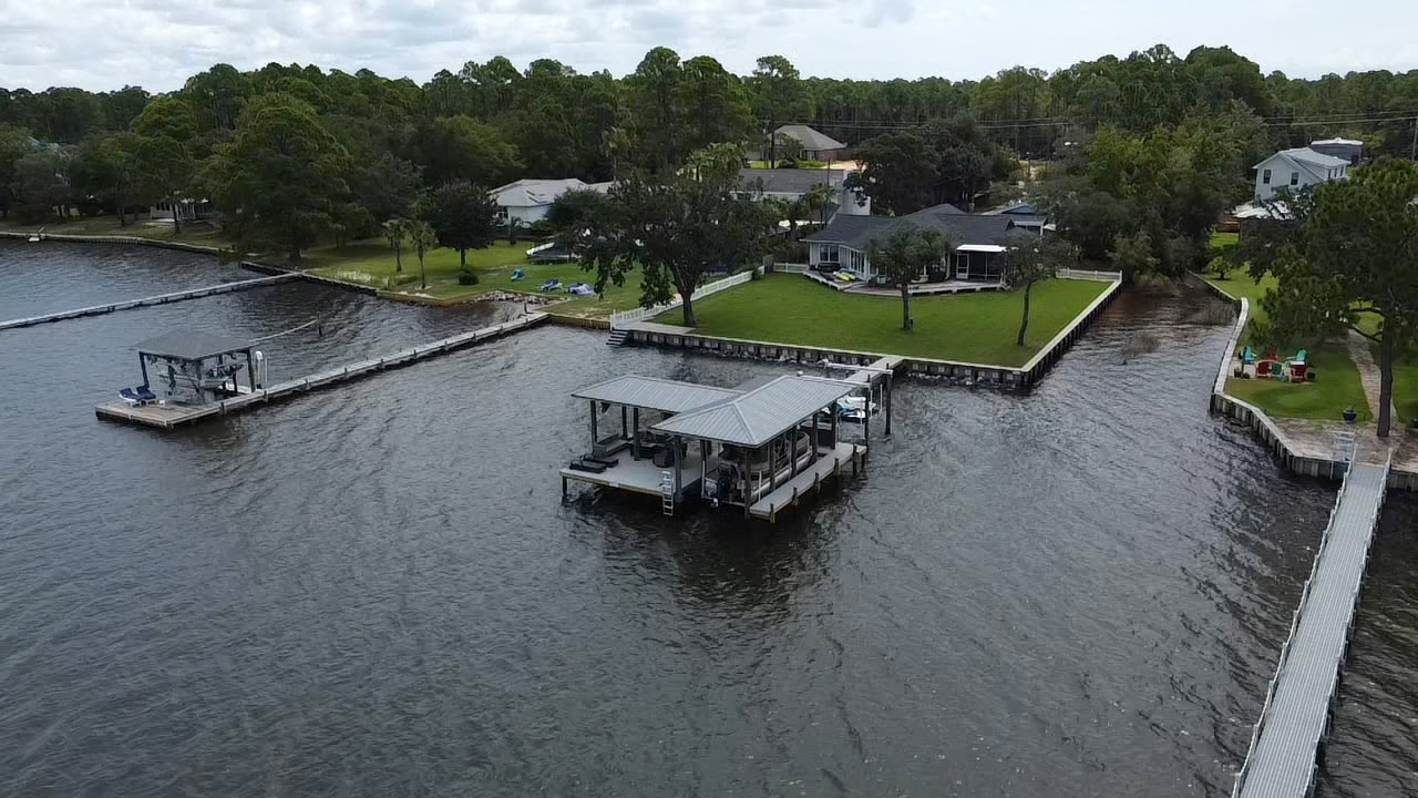 Wide aerial of an SKS Aquatic boathouse, dock and seawall
