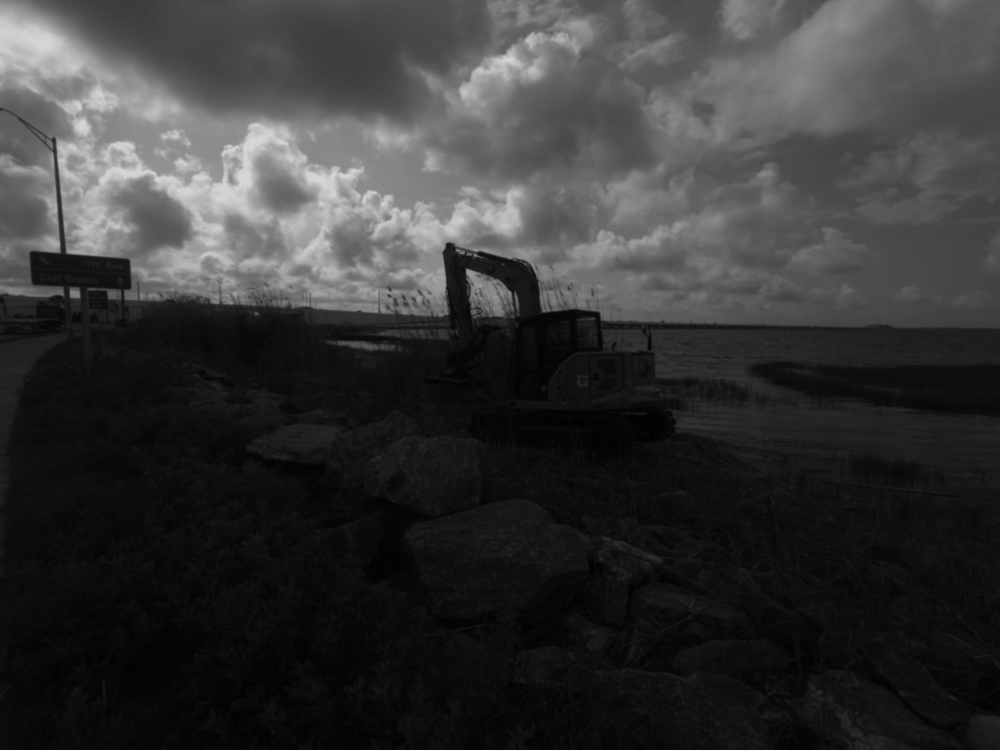 SKS Aquatic excavator mulching vegetation beside a riprap shoreline