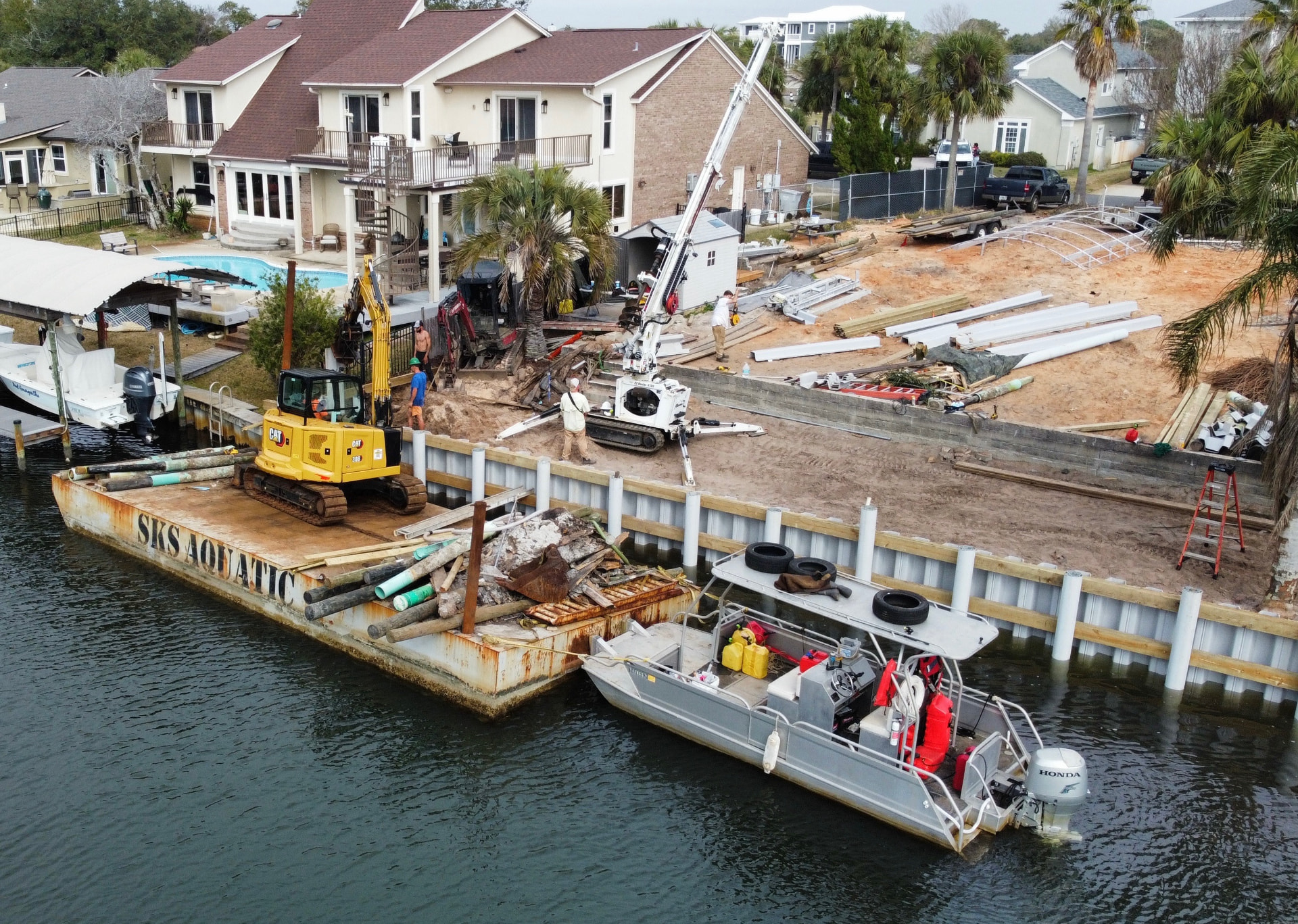 SKS Aquatic crew working from the company barge during seawall construction on Pensacola Bay